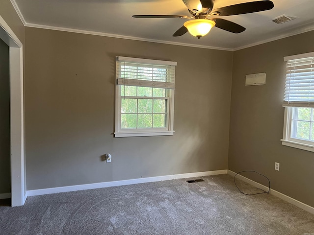 spare room featuring ornamental molding, visible vents, carpet flooring, and baseboards