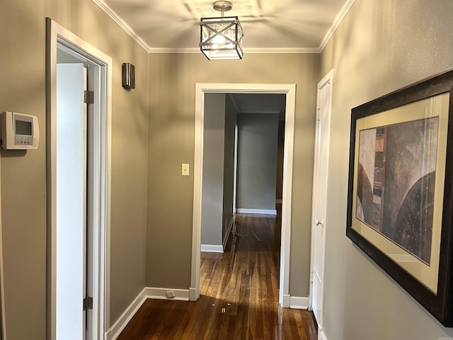 hallway with dark wood finished floors, baseboards, and crown molding