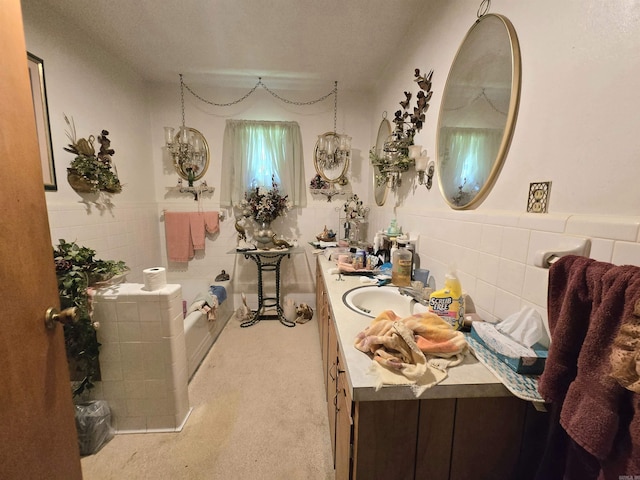 604 N Grand Ave, Mcrae, AR 72102 - bathroom featuring a garden tub, vanity, wainscoting, and tile walls