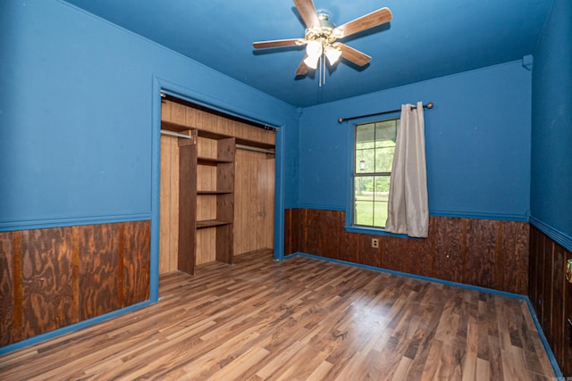 43 Calhoun 11, Hampton, AR 71744 - unfurnished bedroom with wooden walls, a wainscoted wall, a closet, and wood finished floors