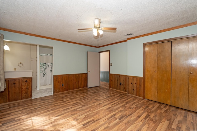 43 Calhoun 11, Hampton, AR 71744 - unfurnished bedroom with a closet, wainscoting, wood finished floors, and a textured ceiling