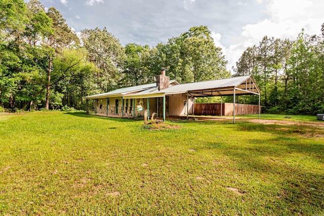 43 Calhoun 11, Hampton, AR 71744 - exterior space featuring a lawn, a chimney, metal roof, and a detached carport