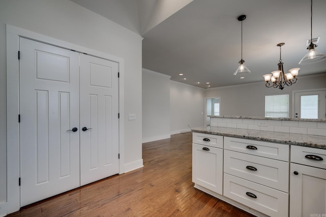 kitchen featuring white cabinets, a chandelier, ornamental molding, and visible vents