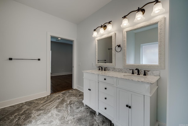 bathroom featuring a sink, baseboards, and double vanity