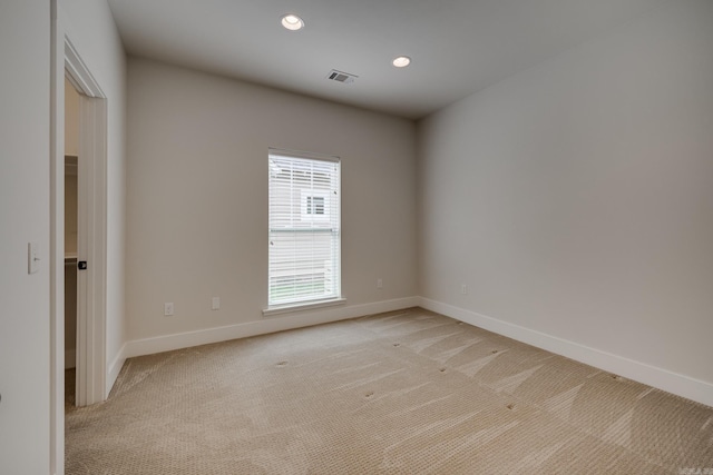 spare room with recessed lighting, baseboards, visible vents, and light carpet