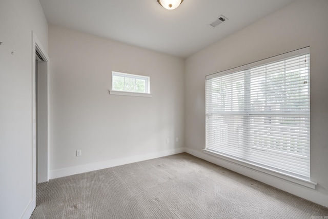unfurnished room featuring carpet floors, baseboards, and visible vents