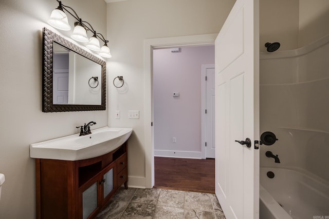 full bathroom with vanity, baseboards, stone finish flooring, and bathing tub / shower combination