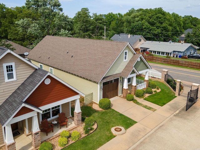 view of front of house with a porch, a garage, fence, and a front lawn
