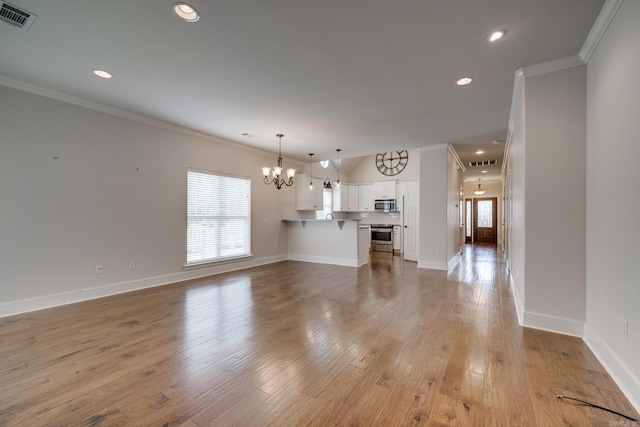 unfurnished living room with crown molding, a notable chandelier, and visible vents