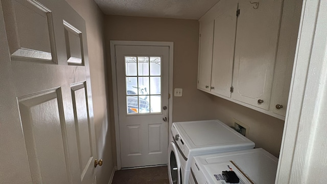 laundry room with cabinet space, a textured ceiling, and washing machine and dryer