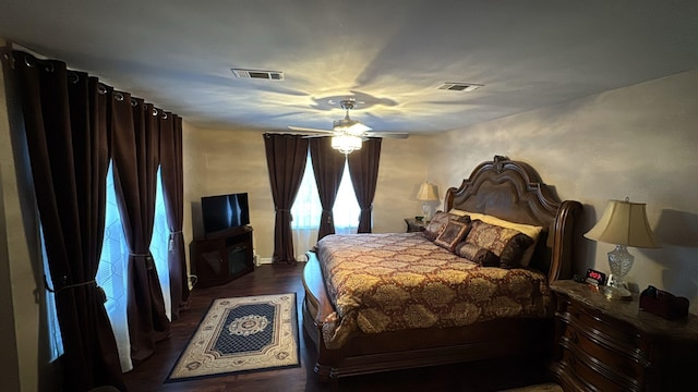 bedroom with visible vents, ceiling fan, and dark wood-type flooring
