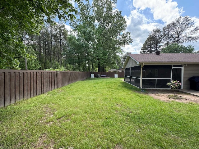 view of yard with a sunroom and a fenced backyard