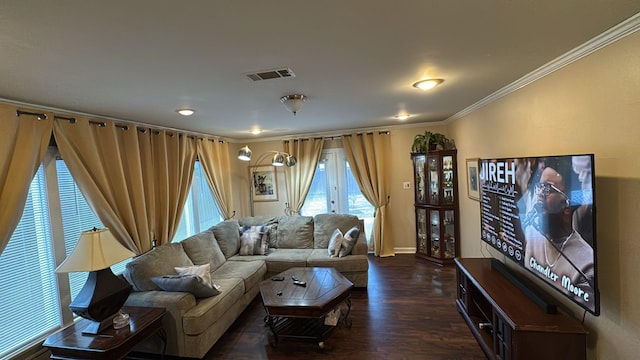 living room featuring baseboards, ornamental molding, wood finished floors, and visible vents
