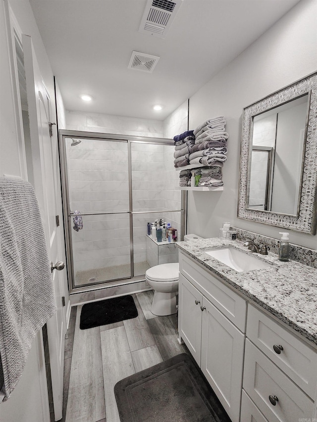 505 E Mississippi St, Beebe, AR 72012 - bathroom with wood finished floors, a stall shower, toilet, vanity, and recessed lighting
