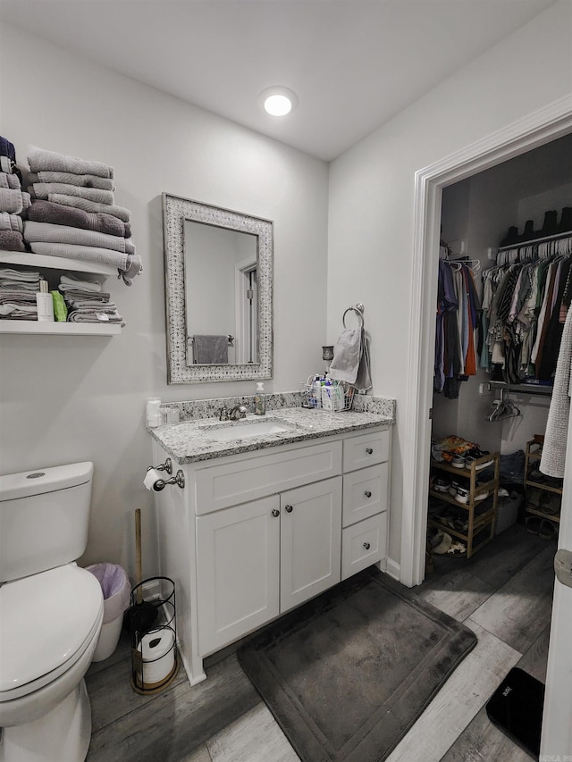 505 E Mississippi St, Beebe, AR 72012 - bathroom with wood finished floors, toilet, vanity, and a walk in closet