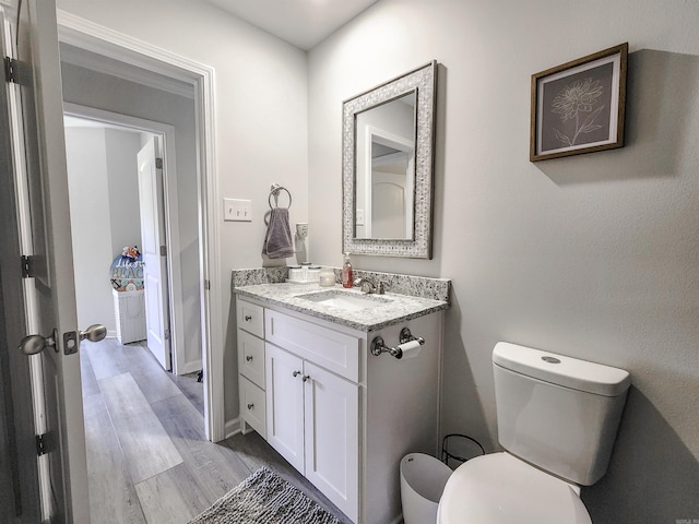 505 E Mississippi St, Beebe, AR 72012 - half bath featuring toilet, vanity, wood finished floors, and baseboards