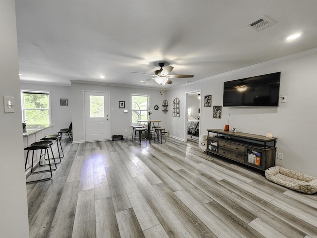 505 E Mississippi St, Beebe, AR 72012 - living room featuring healthy amount of natural light, light wood finished floors, a ceiling fan, crown molding, and recessed lighting