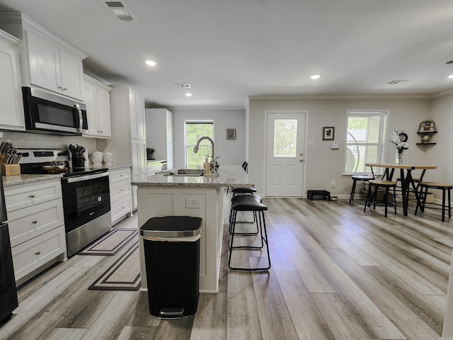 505 E Mississippi St, Beebe, AR 72012 - kitchen featuring appliances with stainless steel finishes, crown molding, a sink, healthy amount of natural light, and a center island with sink