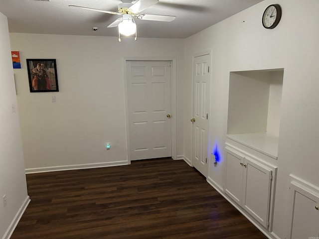 hall featuring baseboards and dark wood-style floors