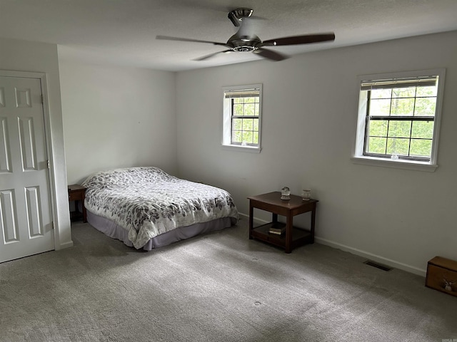 carpeted bedroom featuring visible vents, baseboards, and ceiling fan