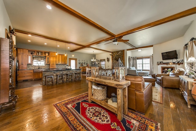 living room with dark wood-style flooring, ceiling fan, plenty of natural light, and beam ceiling