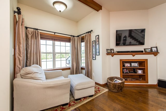 sitting room featuring beamed ceiling, baseboards, and hardwood / wood-style floors