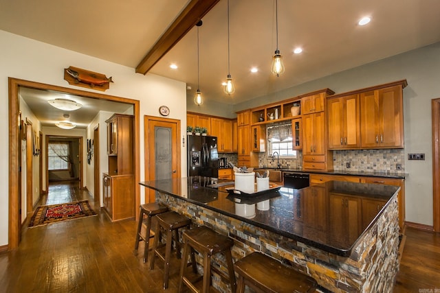 kitchen featuring brown cabinetry, dark wood-style flooring, baseboards, and black appliances