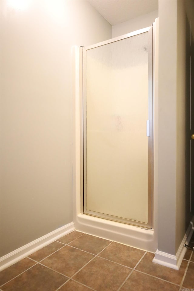 3302 Willow Ln, Paragould, AR 72450 - bathroom with tile patterned floors, a shower stall, and baseboards