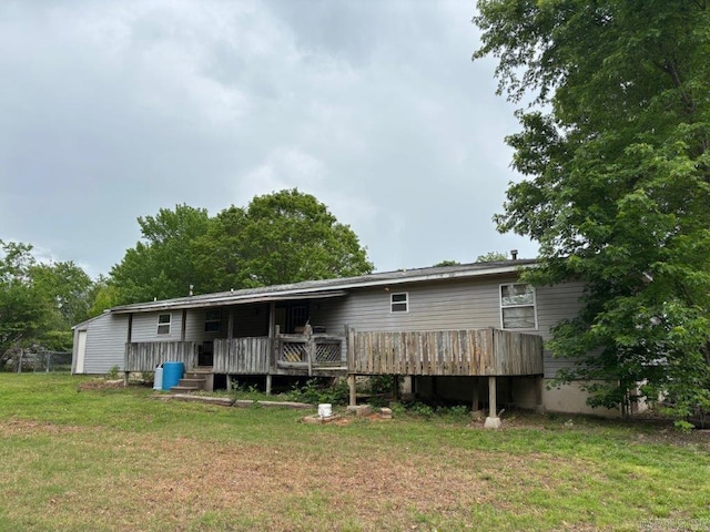 back of property with a yard and a deck