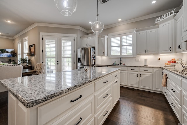 kitchen with ornamental molding, stainless steel fridge, recessed lighting, tasteful backsplash, and a sink