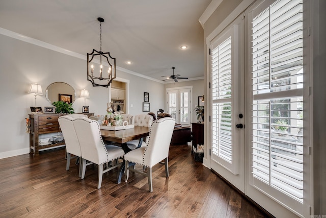 dining space with baseboards, ornamental molding, ceiling fan with notable chandelier, and dark wood-style floors