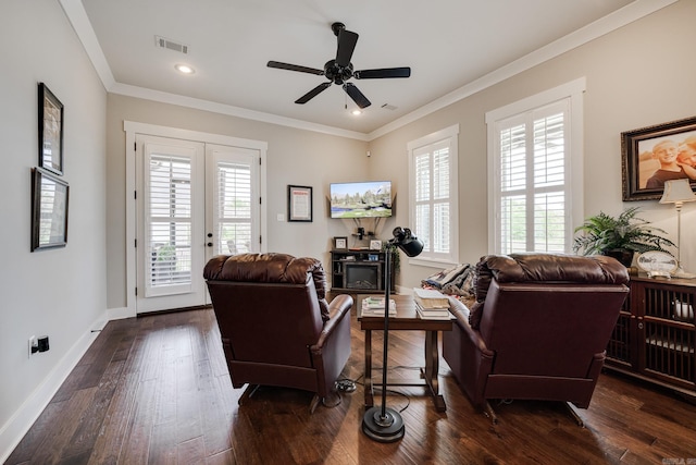 living area with visible vents, ornamental molding, baseboards, a ceiling fan, and dark wood finished floors