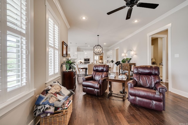 living room with crown molding, ceiling fan with notable chandelier, recessed lighting, and dark wood-type flooring