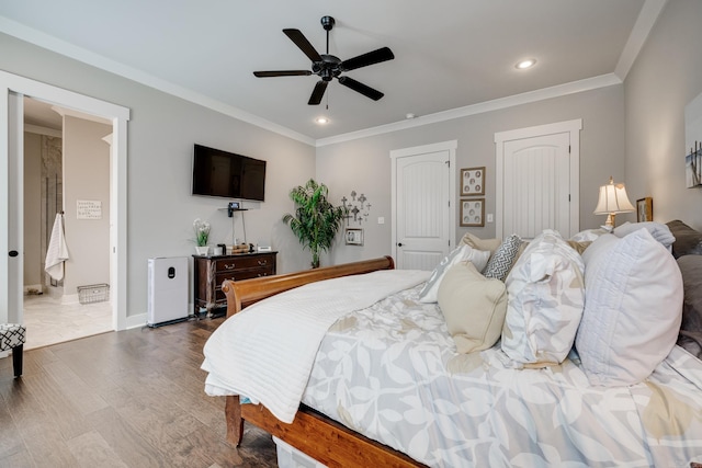 bedroom featuring two closets, recessed lighting, ornamental molding, and wood finished floors