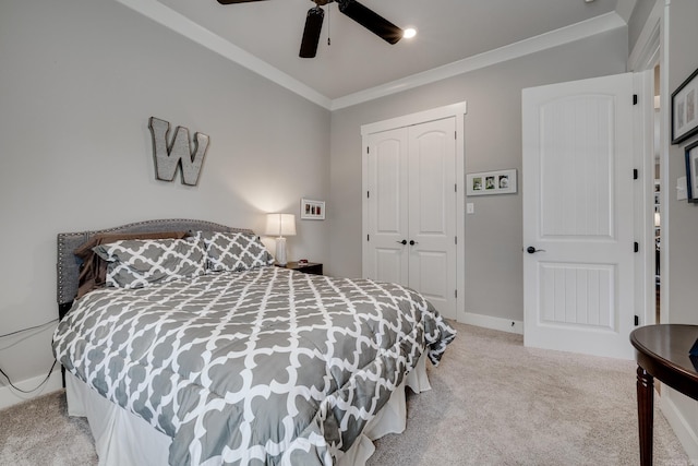 bedroom with light colored carpet, crown molding, a closet, and ceiling fan