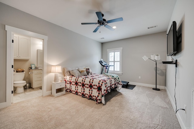 bedroom featuring baseboards, light carpet, ensuite bath, and visible vents