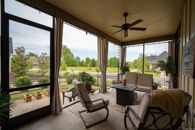 sunroom / solarium featuring a healthy amount of sunlight, ceiling fan, and an outdoor living space