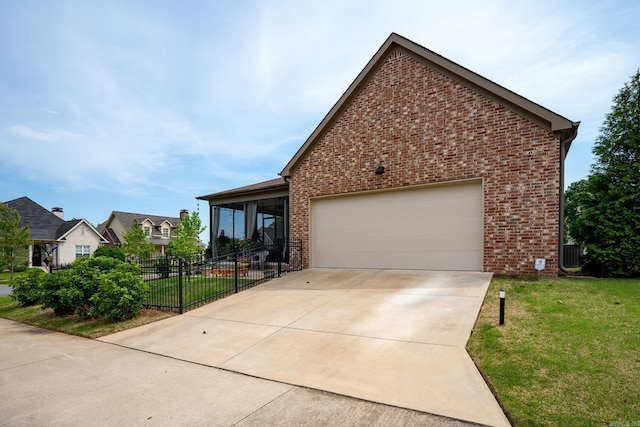 view of front of home featuring brick siding, a front lawn, fence, and concrete driveway