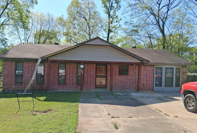 ranch-style home featuring brick siding, roof with shingles, and a front yard