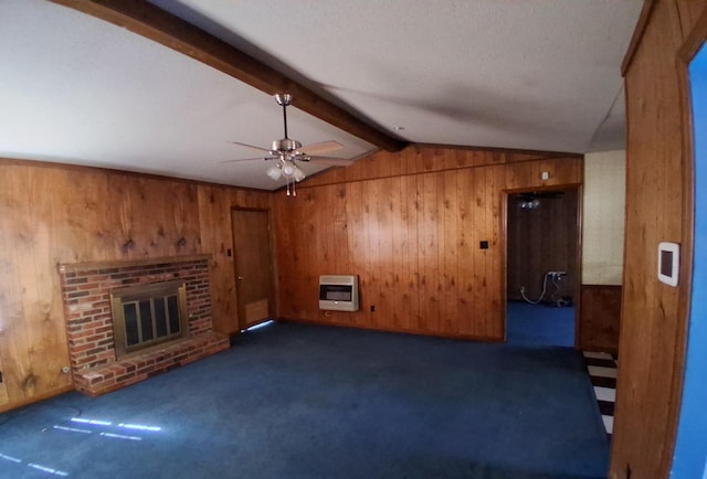unfurnished living room with ceiling fan, heating unit, dark colored carpet, wooden walls, and vaulted ceiling with beams
