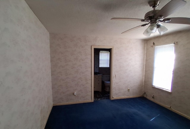 carpeted empty room with baseboards and ceiling fan