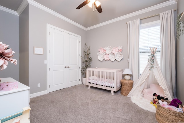 carpeted bedroom featuring crown molding, a nursery area, baseboards, and a closet