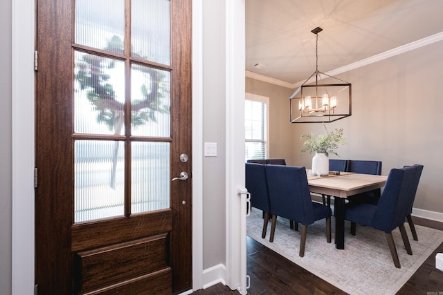 dining space featuring crown molding, a chandelier, baseboards, and dark wood finished floors