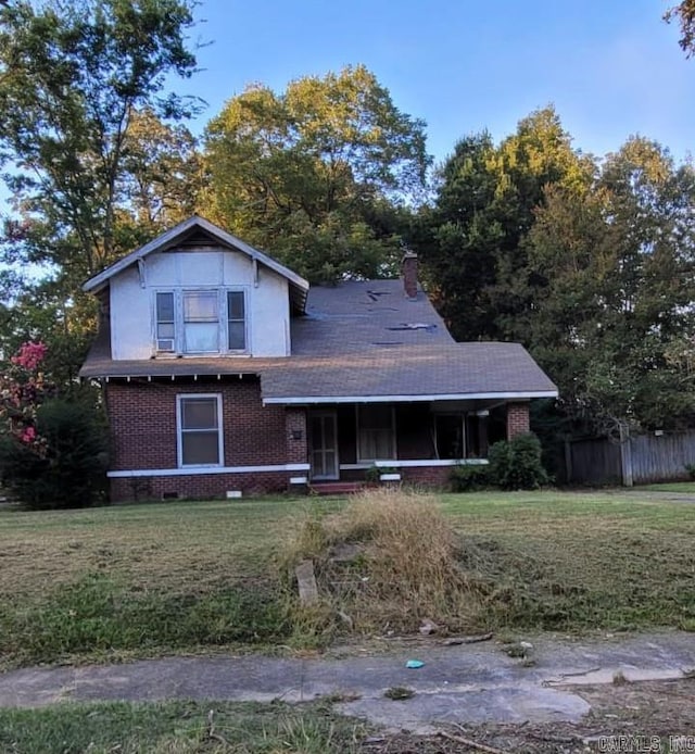 view of front of property with fence, brick siding, a porch, a front yard, and crawl space