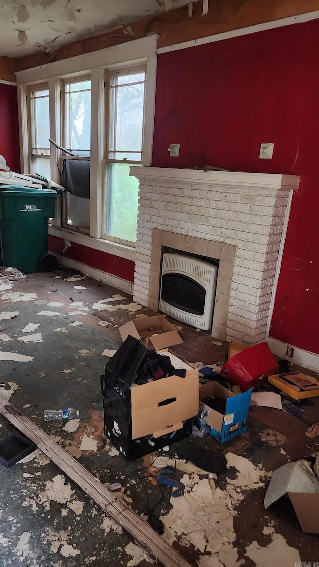living room featuring heating unit and a brick fireplace