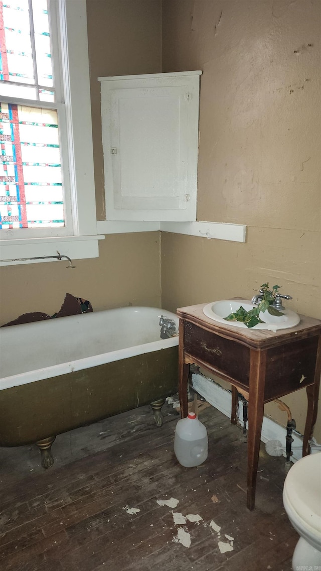 bathroom with a bath and hardwood / wood-style flooring