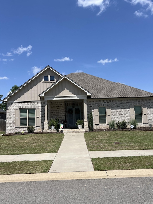 2560 Lilac Dr, Conway, AR 72034 - view of front of house with brick siding, a front yard, board and batten siding, and a shingled roof
