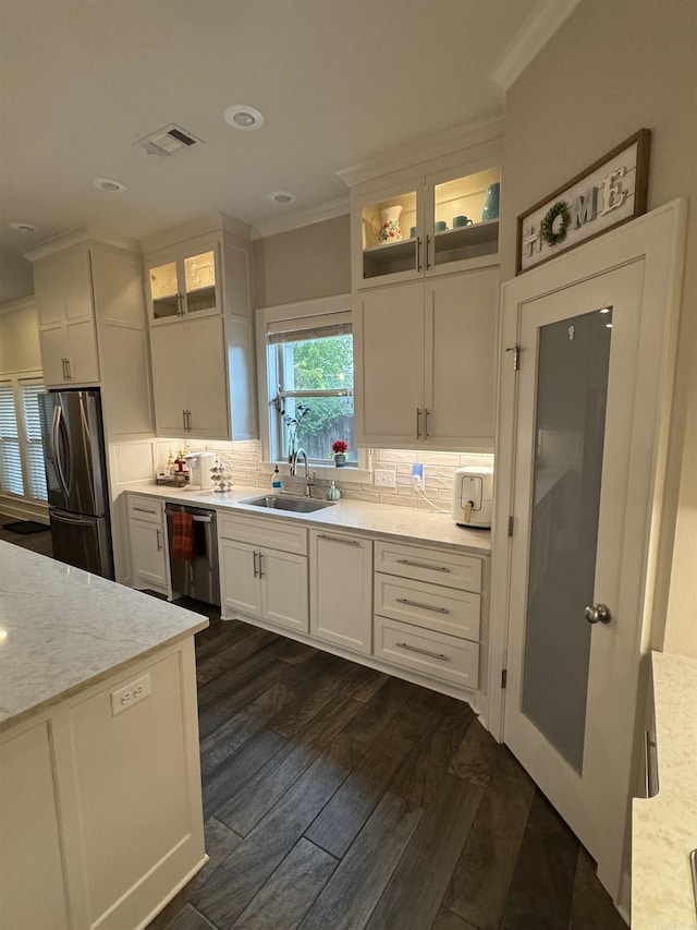 2560 Lilac Dr, Conway, AR 72034 - kitchen with stainless steel appliances, a sink, ornamental molding, dark wood-style flooring, and white cabinets