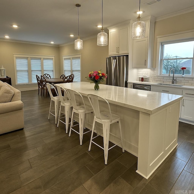 2560 Lilac Dr, Conway, AR 72034 - kitchen featuring a sink, freestanding refrigerator, ornamental molding, a kitchen island, and white cabinetry