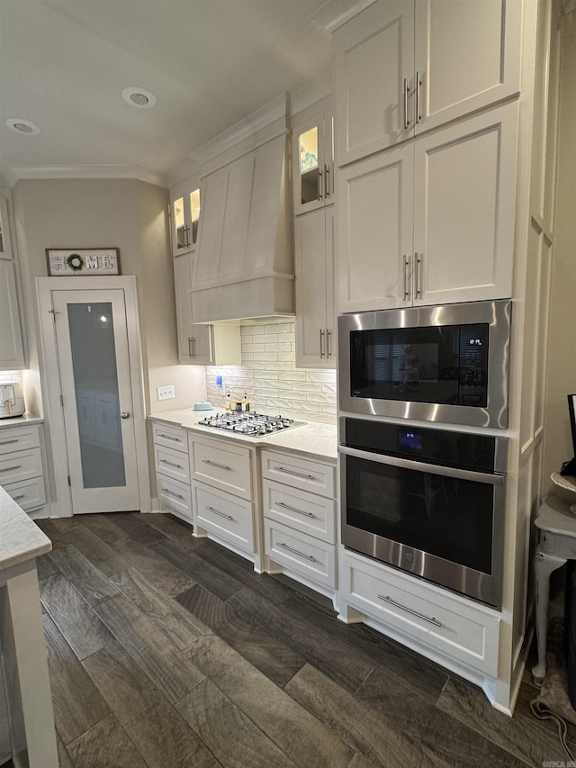 2560 Lilac Dr, Conway, AR 72034 - kitchen featuring stainless steel appliances, ornamental molding, dark wood-style floors, white cabinetry, and custom range hood